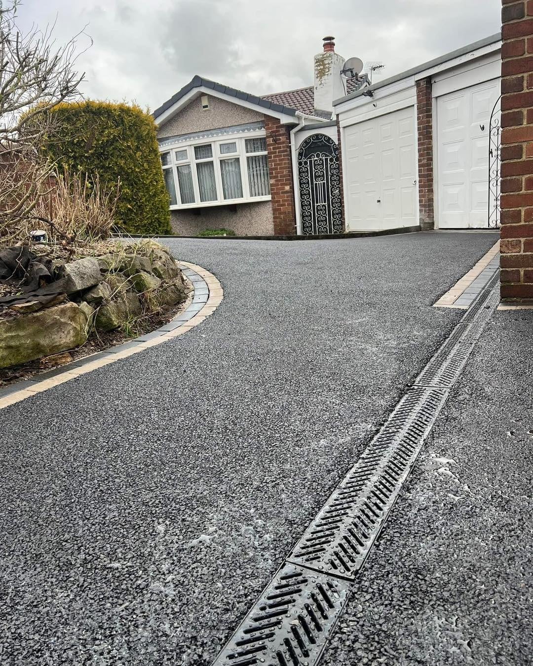 Textured grey resin driveway with linear drainage