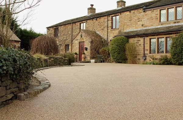 Golden resin driveway outside a stone cottage