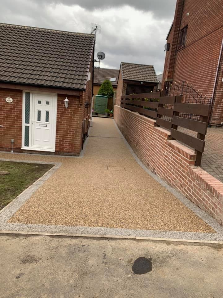 Warm resin side driveway between brick homes